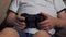Close-up of a small child playing video games at home, he holds a joystick.