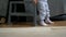 Close-up of a small child walking on the carpet. Little baby feet. Girl goes to her mom, first steps