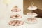 Close up of small delicious sweets in pink and white colors stand with charming decor