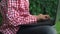 Close-up of small female hands working on a laptop keyboard girl sitting on the grass outside in the park. Rest and work