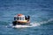 Close up of small fishing boat heading into shore at Beer beach, Devon, UK