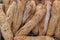 A close up of small freshly baked rustic baguettes for sale at a farmers market