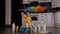 Close-up of a small girl playing in the kitchen with detergents and brushes.