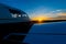 Close-up of a small parked plane with a propeller against the backdrop of a sunset.