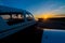 Close-up of a small parked plane with a propeller against the backdrop of a sunset.