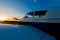 Close-up of a small parked plane with a propeller against the backdrop of a sunset.