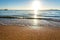 Close up of small sea waves with clear blue water over yellow sand beach at summer sunny shore