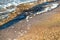 Close up of small sea waves with clear blue water over yellow sand beach at summer sunny shore