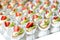 Close up of small sweet canapes arranged on a mirror plate over light background