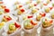 Close up of small sweet canapes arranged on a mirror plate over light background