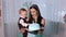 Close-up of small year old boy eating cake with his hands and feeding his mother