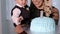 Close-up of small year old boy eating cake with his hands and feeding his mother