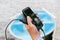 Close-up, Smartphone with charging from a Power bank in a man`s hand. Against the background of a boat on the water