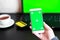 Close Up of a Smartphone with Green Screen for chroma key compositing. Person is shopping online with credit card and phone on