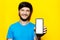 Close-up of smartphone with mockup in hand of blurred smiling guy on yellow background.