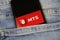 Close up of smartphone screen in blue jeans pocket with logo lettering of russian mobile phone provider MTS Telesystems
