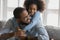 Close up smiling African American father piggy backing adorable daughter