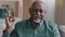 Close up smiling african american mature man portrait pleased pensioner male sitting in apartment happy wrinkled face