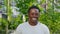 Close up smiling afro-american man looks camera on background modern building