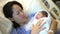 Close-up and smiling asian Chinese mother lying on hospital bed and carrying her newborn