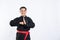 Close up of smiling Asian man wearing pencak silat uniform standing with respectful hand gestures