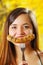 Close up of smiling beautiful young woman pointing in front of her mouth a piece of sausage using a fork, looks like a