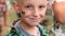 close up of smiling child with painted Ukrainian flag on face. Protest against Russian war invasion in Ukraine