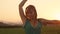 CLOSE UP: Smiling girl gets drenched while she dances on a beautiful evening.