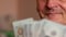 Close-up of smiling grandfather, pensioner 70 years older, counts dollar banknotes. Home savings, budgeting retiree. Elderly Cauca