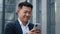 Close up smiling laughing Asian middle-aged Korean businessman man employer entrepreneur laugh looking at mobile phone