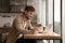 Close up smiling man using laptop, taking notes, studying online