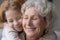 Close up smiling mature woman with little granddaughter hugging