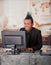 Close up of smiling office punk worker wearing a suit with a crest, working in a computer, in a blurred background