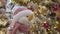 Close-up of smiling soft toy hanging on Christmas tree in shopping center. Nice little snowman between decorations of