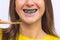 Close up of smiling woman brushing teeth with eco friendly bamboo toothbrush with black charcoal whitening toothpaste