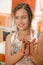 Close up of smiling woman ceramist working on sculpture on wooden table in workshop, in a blurred background