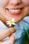 Close-up smiling woman holding flower camomile