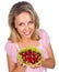 Close up of smiling woman holding raspberries