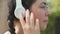 Close up of smiling woman's face is wearing headphones and listen a music or podcast. Girl push the button in