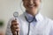 Close up smiling young Indian doctor holding stethoscope in hands.