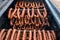 Close-up of smoked sausages from pork and beef meat hanging inside a wooden smokehouse