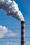 A close-up of the smoking chimneys of a coal-fired power plant.