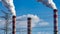 A close-up of the smoking chimneys of a coal-fired power plant.