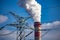 A close-up of the smoking chimneys of a coal-fired power plant.