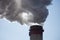 A close-up of the smoking chimneys of a coal-fired power plant.