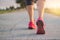 Close up sneaker of athlete woman runner feet on rural road while running exercise on sunset background