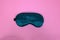 Close up of soft clean green satin sleeping mask isolate on pink background