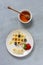 Close-up of soft Viennese waffles on the plate with blueberries, strawberry and honney