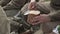 Close-up of soldiers in a Russian military uniform from the Second World War slices bread with a knife