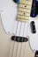 Close up of solid electric bass guitar in vintage antique white